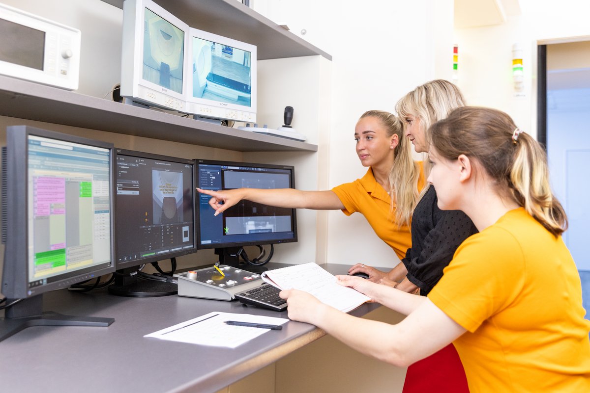 Arzthelferinnen und Ärztin vor einem Computer